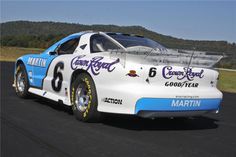 a white and blue race car driving down the road