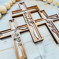 a large wooden cross sitting on top of a table next to some beads and stones