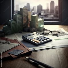 a calculator, pen and glasses sitting on top of papers with cityscape in the background