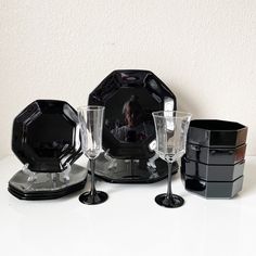 a table topped with black plates and glasses