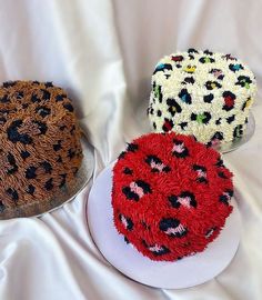 three cakes are sitting on top of each other, one is decorated with animal print