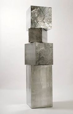 a stack of metal blocks sitting on top of each other in front of a white wall