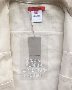 a white jacket with a red tag on it and the words special museum exhibition product