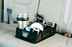 the back seat of a car with a cup and other items in it