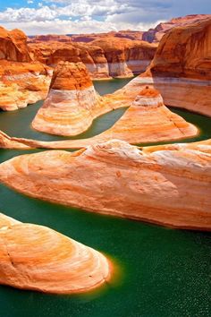 the water is green and blue in this desert area with large rocks on both sides