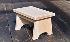 a small wooden stool sitting on top of a wooden floor