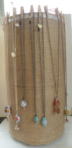 several different necklaces are hanging on a display rack in front of a window,