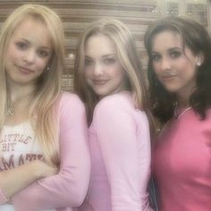 three beautiful young women standing next to each other