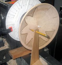 a wooden spinning wheel being worked on with a pencil