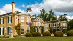 a large yellow house surrounded by lush green trees