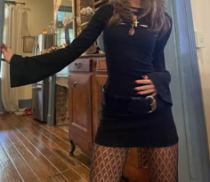 a woman standing in front of a mirror with her hands on her hips and wearing tight stockings