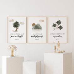 three framed art prints on the wall above white cubes