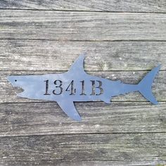 a metal sign with a shark on it that says,'18lbb '