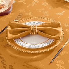 a plate with a bow tie on it next to a fork and knife, along with other place settings