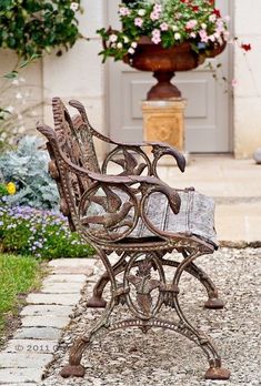 an old iron bench sitting in front of a house