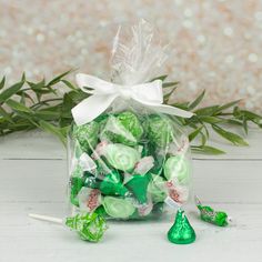 a bag filled with green and white candy lollipops next to some leaves