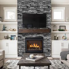 a living room with a fire place in the center and shelves on either side of the fireplace