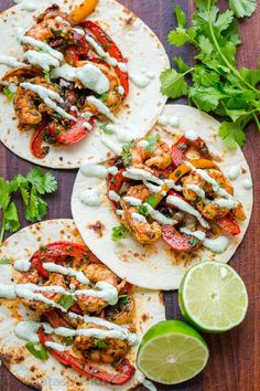 three chicken fajitas with cilantro, lime and sour cream on top