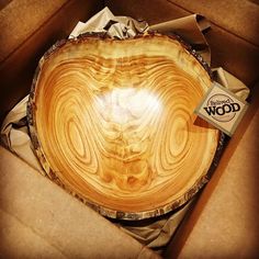 a wooden bowl sitting on top of a cardboard box