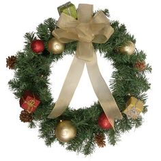 a christmas wreath with gold ornaments and a bow on the front, hanging from a white wall