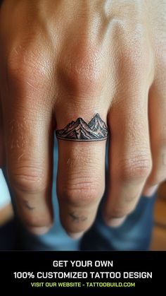 a man's hand with a mountain tattoo on the middle finger that reads get your own 100 % customized tattoo design visit our website