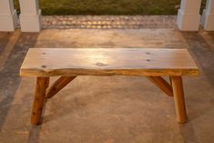 a wooden bench sitting on top of a cement floor