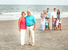 a group of people standing on top of a sandy beach