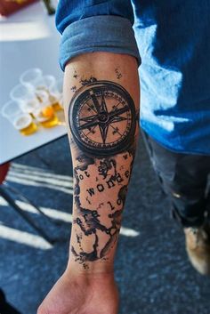 a man with a compass tattoo on his arm