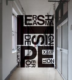 an empty hallway with black and white letters on the wall