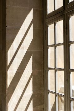 the sun is shining through two windows in an old building with stone walls and flooring