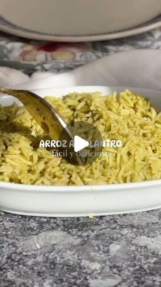 a white bowl filled with yellow rice on top of a table