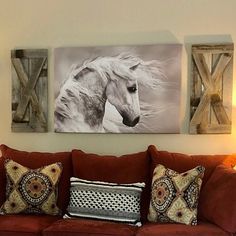 a living room filled with furniture and paintings on the wall above it's couch