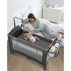 a woman laying in bed next to a baby and changing table with an infant on it