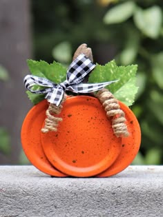 an orange pumpkin with a black and white checkered bow