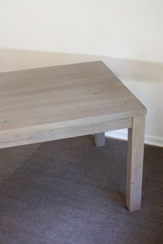 a wooden table sitting on top of a carpeted floor