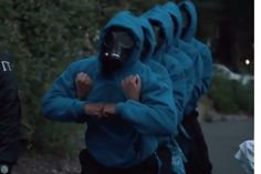 a group of people wearing gas masks on their faces and arms, all in blue jackets