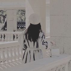 a woman in a white hat is sitting on a bench