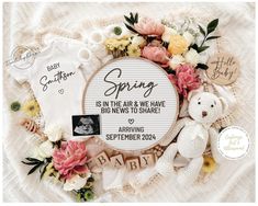 a baby announcement with flowers and teddy bear on the blanket next to it is an embroidered frame that says, spring is in the air & we have been to share