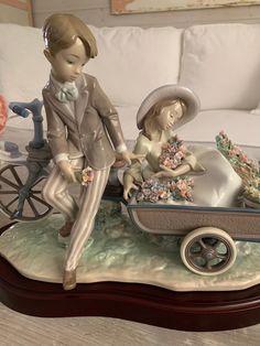 a figurine is sitting on a table next to a toy baby in a stroller