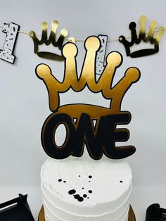 there is a cake that has been decorated with gold and black letters on top of it