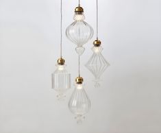 three clear glass pendant lights hanging from a ceiling