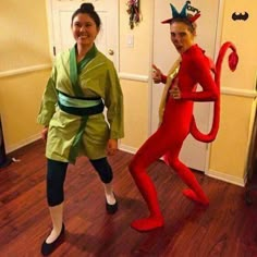 two women in costumes standing next to each other on a hard wood floored room