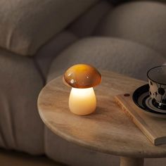 a mushroom lamp sitting on top of a table next to a cup and saucer