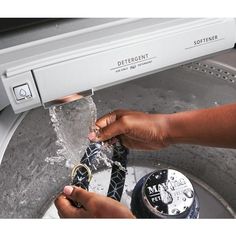 a person is washing their hands under the faucet in a dishwasher