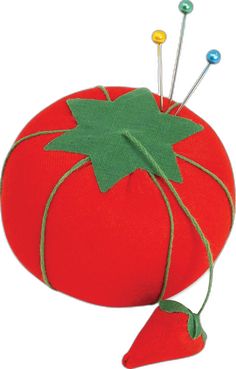 a tomato pillow with pins stuck to it