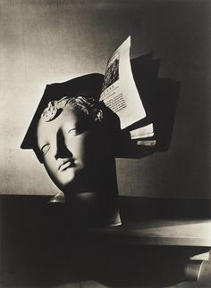 a black and white photo of a person's head with books in the background