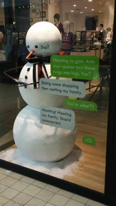 a snowman is sitting in front of a store window with two messages written on it