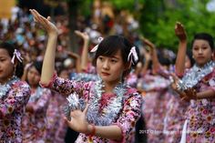 young women in colorful outfits are dancing with tinsel on their heads and hands together