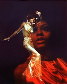 an image of a woman in gold and red with her hands on her head, posing for the camera