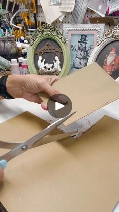 a person cutting out a piece of cardboard with scissors